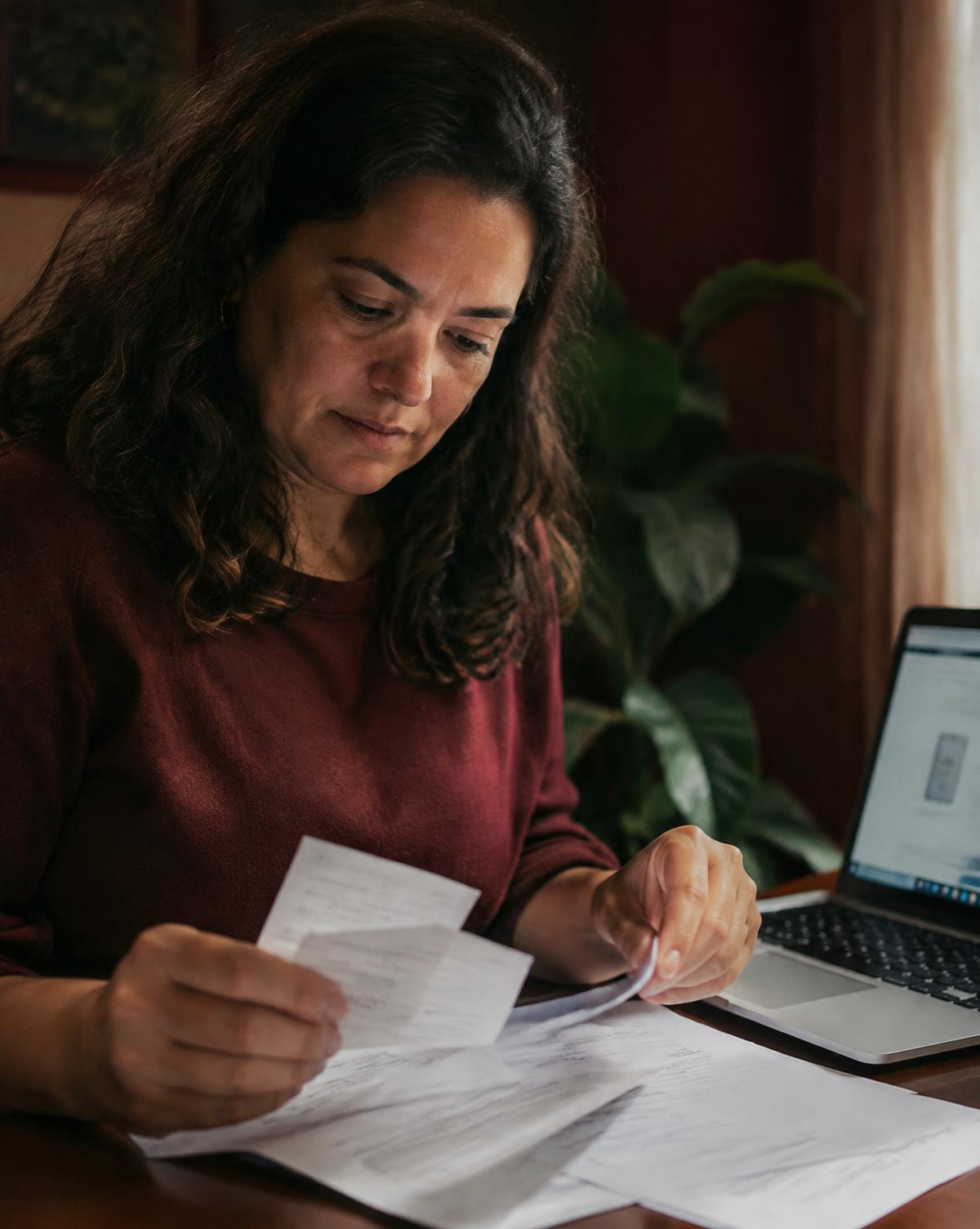 Imagem ilustrativa: mulher conferindo comprovantes de compra